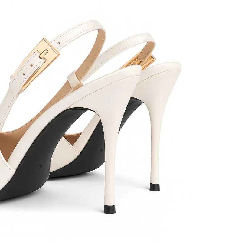 Detalhe do salto agulha e da alça traseira do scarpin branco slingback. A foto em close aproxima a fivela dourada, o salto de 9 cm e a sola preta, evidenciando a qualidade.