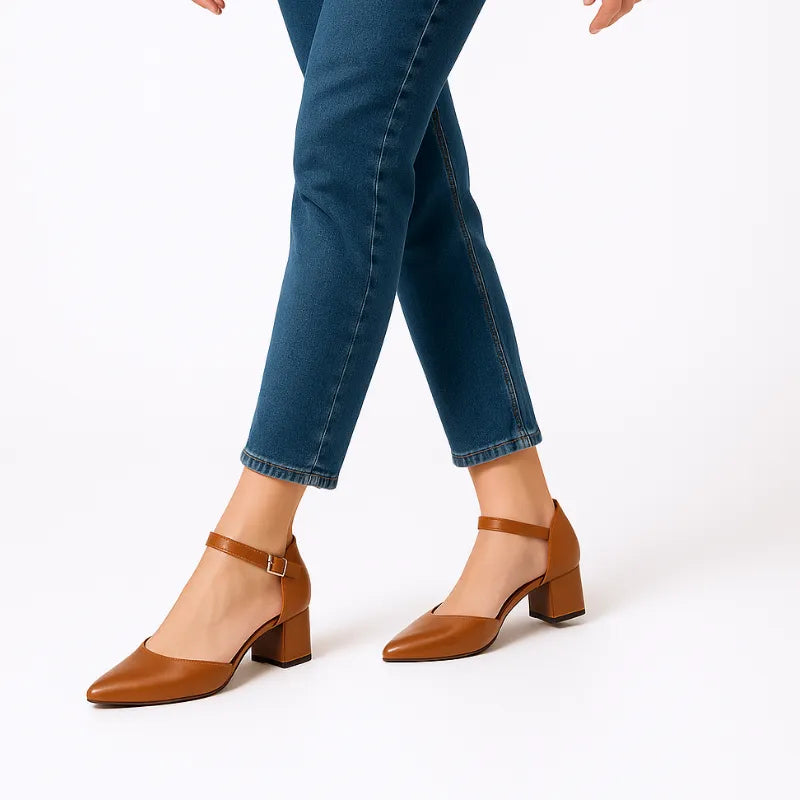 Modelo usando o scarpin marrom com salto bloco da Rozze, em pé. A foto de perfil realça a estabilidade e a forma do sapato no pé.