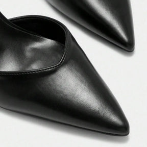 Detalhe da tira e do bico do scarpin preto com tira no tornozelo da Rozze. A imagem aproxima a fivela ajustável na tira do tornozelo e a forma elegante do bico fino, elementos que proporcionam segurança e sofisticação.