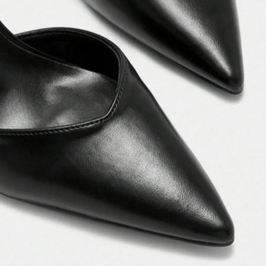Detalhe da tira e do bico do scarpin preto com tira no tornozelo da Rozze. A imagem aproxima a fivela ajustável na tira do tornozelo e a forma elegante do bico fino, elementos que proporcionam segurança e sofisticação.