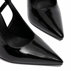 Detalhe do bico e do material do scarpin preto de verniz. A imagem em close aproxima o acabamento brilhante e o design sofisticado do calçado.