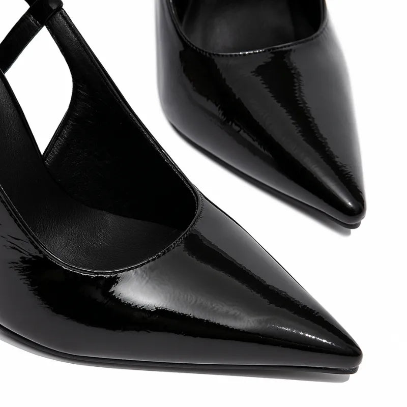 Detalhe do bico e do material do scarpin preto de verniz. A imagem em close aproxima o acabamento brilhante e o design sofisticado do calçado.