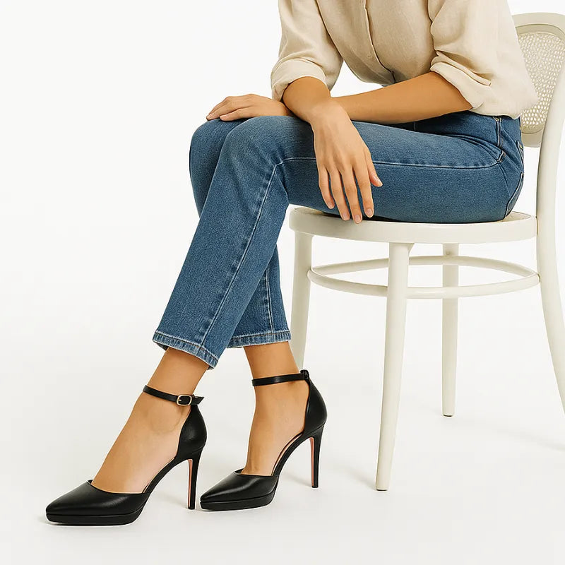 Modelo usando o scarpin de salto alto Scarlett da Rozze, sentado. A imagem mostra o calçado em uso, complementando um look casual elegante com calça jeans.