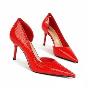 Par de scarpins vermelhos com textura crocodilo. A imagem realça o bico fino alongado e o acabamento brilhante do verniz.