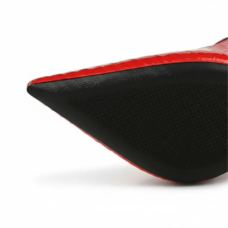 Detalhe da ponta do scarpin e da sola preta. A foto destaca o contraste entre o vermelho vibrante e o solado resistente.