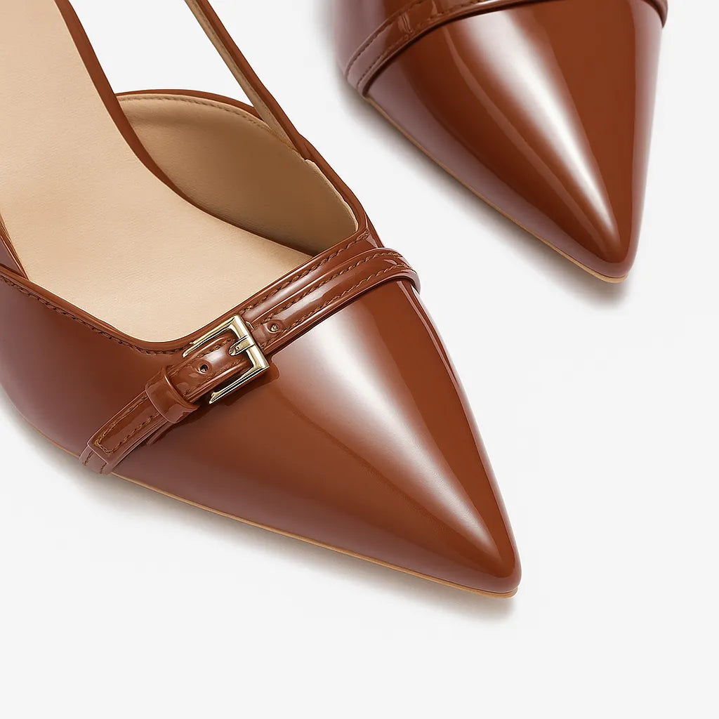 Detalhe do bico e do material do scarpin castanho de verniz. A imagem em close aproxima o acabamento brilhante e o design sofisticado do calçado.
