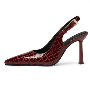 Scarpin feminino croco marsala, vista lateral. A foto em estúdio destaca o salto agulha de 9 cm, o bico fino e a alça slingback ajustável.