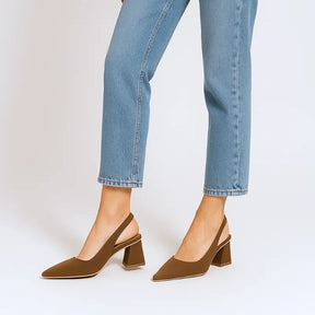 Vista de perfil da modelo usando o scarpin slingback marrom da Rozze. A foto realça a silhueta do calçado no pé, combinando com calça jeans de barra dobrada.