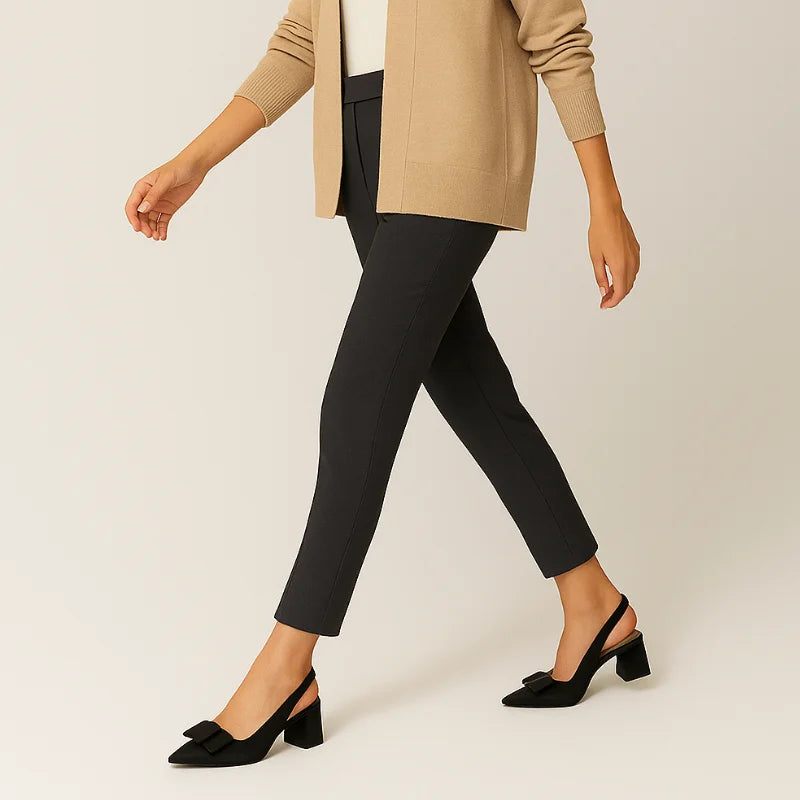 Modelo em movimento usando o scarpin slingback preto com laço da Rozze. A imagem realça a versatilidade do calçado e o design que se adapta a diferentes looks.