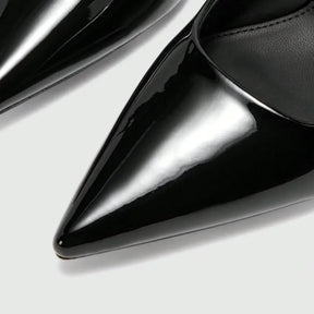 Detalhe do bico e do material do scarpin preto de verniz. A imagem em close aproxima o acabamento brilhante, o bico fino e o design sofisticado.