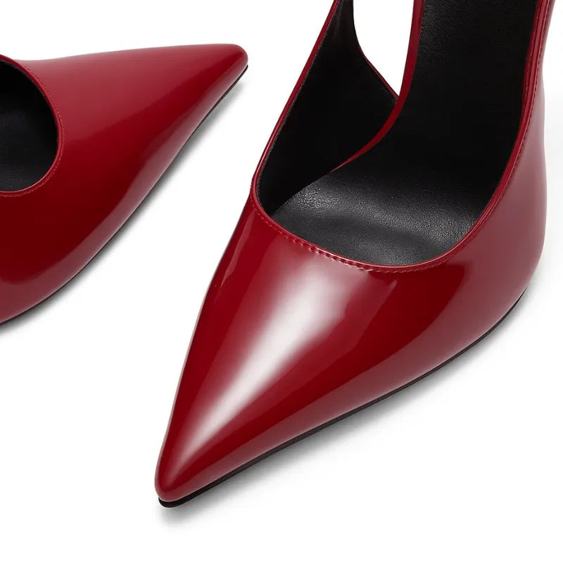 Detalhe do scarpin slingback vermelho. A imagem em close aproxima o bico fino e o acabamento em couro PU, mostrando a elegância do calçado.