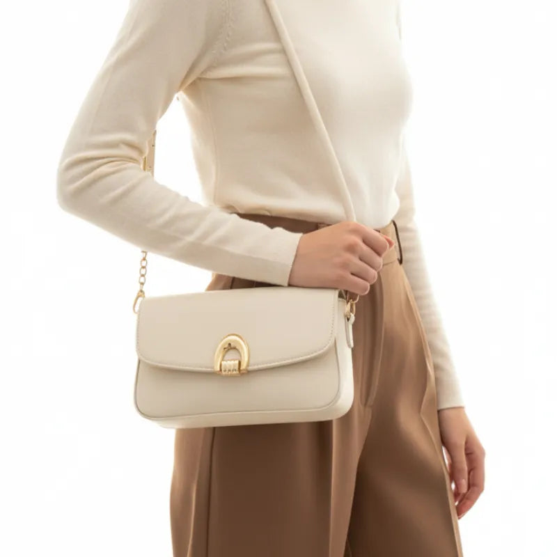 Bolsa baguete off white fecho metálico usada no ombro pela modelo, mostrando proporção e caimento frontal