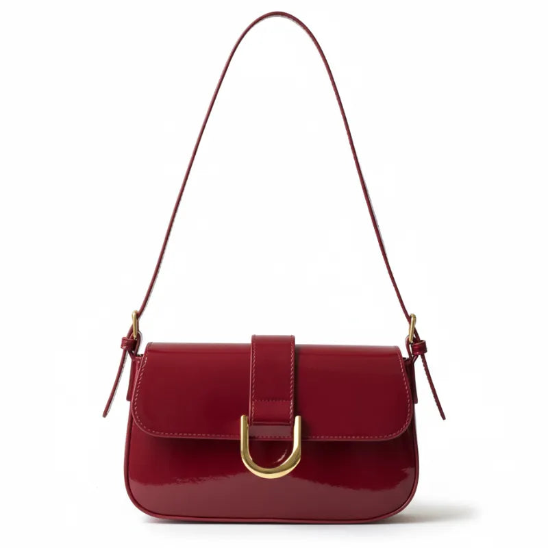 Bolsa baguete vermelho verniz fivela dourada em vista frontal, com formato, alça e ferragens visíveis, sobre fundo claro