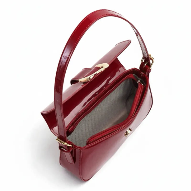 Bolsa baguete vermelho verniz fivela dourada aberta por cima, com forro, espaço interno e fechamento visíveis