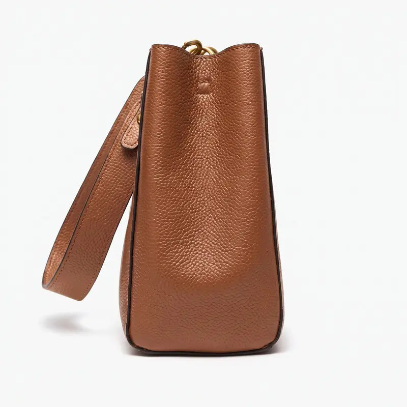 Bolsa bucket feminina marrom em couro legítimo em vista lateral, mostrando profundidade, alça e estrutura.