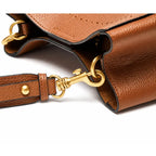 Bolsa bucket feminina marrom em couro legítimo em detalhe, destacando textura, ferragens e acabamento do material.