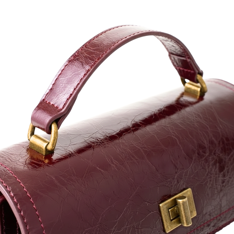 Bolsa crossbody feminina couro vinho Rozze em close mostrando fecho e alça.