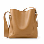 Bolsa de ombro caramelo em couro legítimo em vista frontal, destacando formato, alça larga e acabamento do couro.