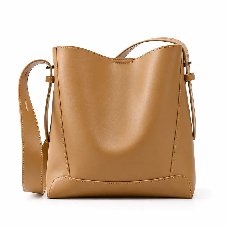 Bolsa de ombro caramelo em couro legítimo em vista frontal, destacando formato, alça larga e acabamento do couro.