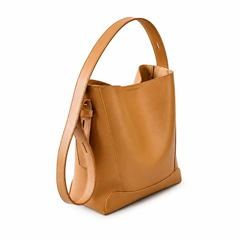 Bolsa de ombro caramelo em couro legítimo vista por trás, destacando costuras e acabamento posterior.