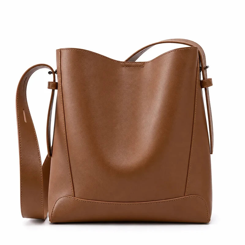 Bolsa de ombro marrom em couro legítimo em vista frontal, destacando formato, alça larga e acabamento do couro.