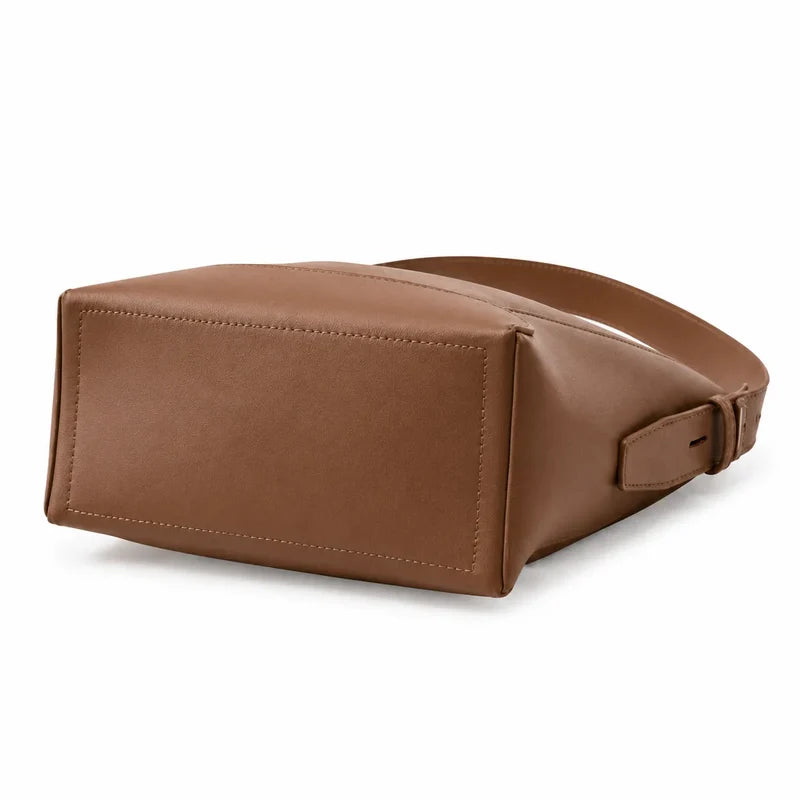 Bolsa de ombro marrom em couro legítimo vista por trás, destacando costuras e acabamento posterior.