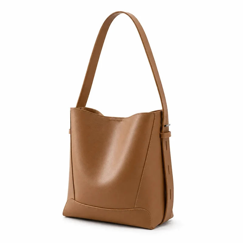 Bolsa de ombro marrom em couro legítimo em ângulo três-quartos, mostrando formato, volume e alça.