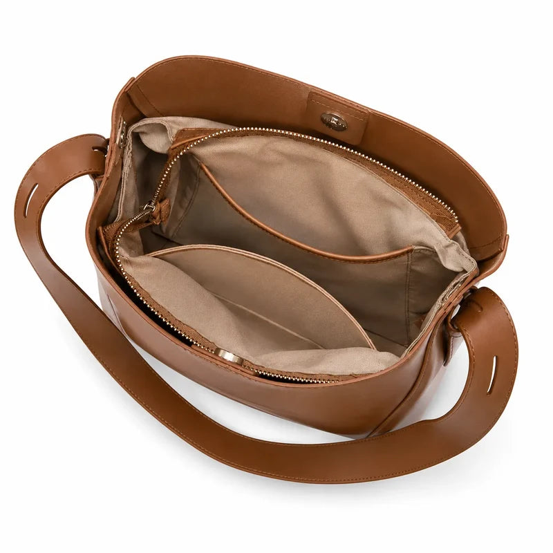 Bolsa de ombro marrom em couro legítimo em composição de produto, destacando proporção, caimento e acabamento.