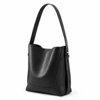 Bolsa de ombro preta em couro legítimo em ângulo três-quartos, mostrando formato, volume e alça.