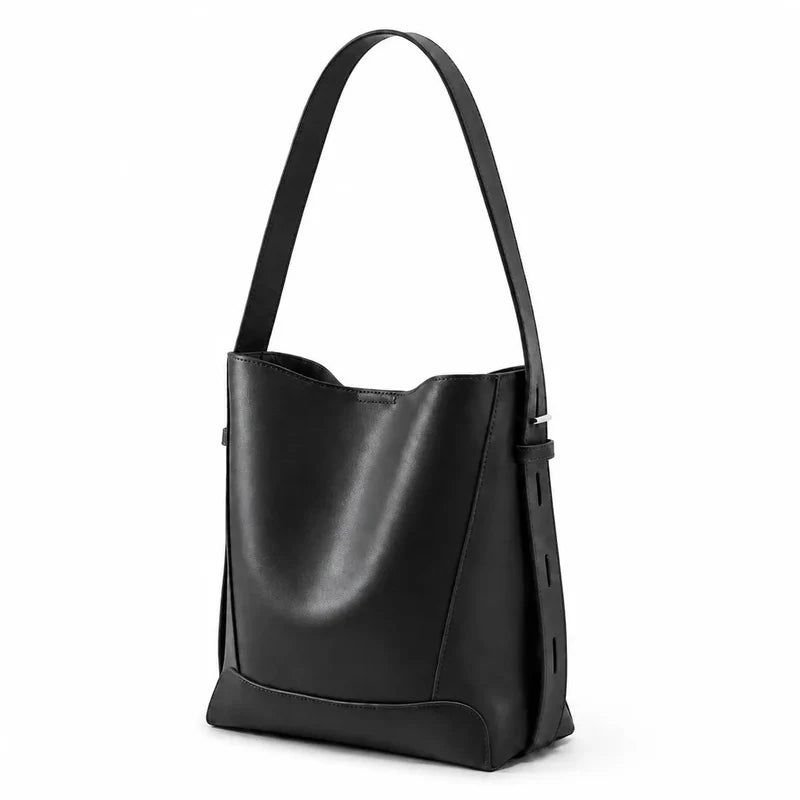 Bolsa de ombro preta em couro legítimo em ângulo três-quartos, mostrando formato, volume e alça.
