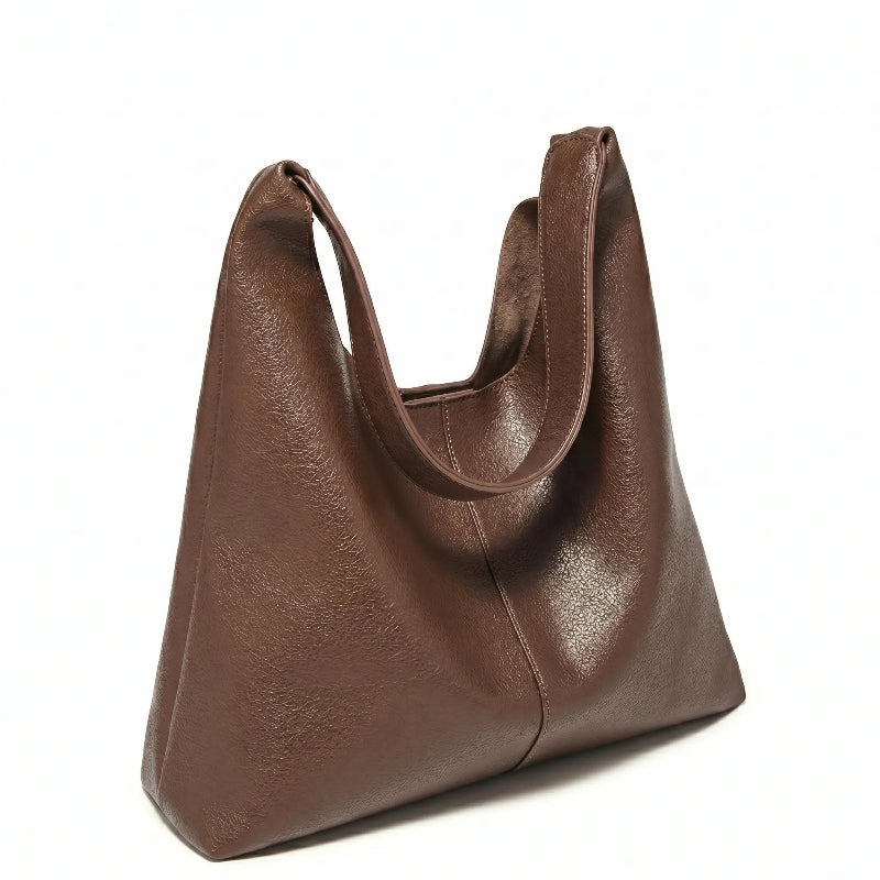 Bolsa feminina hobo marrom em couro texturizado usada pela modelo em vista lateral, com caimento e ajuste da alça