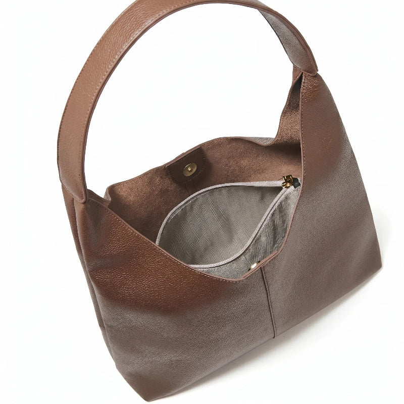 Bolsa feminina hobo marrom em couro texturizado em close na textura do material, com padrão e costuras visíveis
