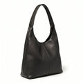 Bolsa feminina hobo preta em couro texturizado em vista lateral, com profundidade, alça e acabamento visíveis