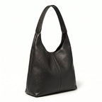 Bolsa feminina hobo preta em couro texturizado em vista lateral, com profundidade, alça e acabamento visíveis