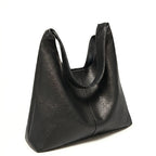 Bolsa feminina hobo preta em couro texturizado em close na textura do material, com padrão e costuras visíveis