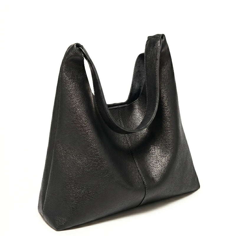Bolsa feminina hobo preta em couro texturizado em close na textura do material, com padrão e costuras visíveis