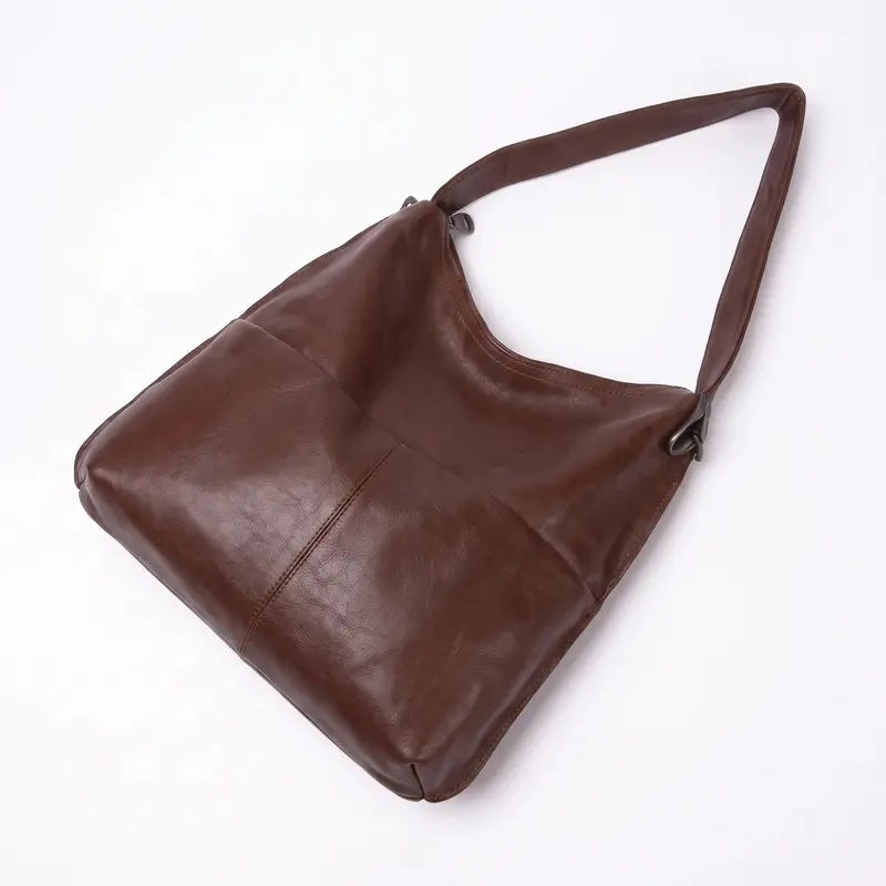 Bolsa hobo clássica castanho em couro legítimo vista por trás, destacando costuras e acabamento posterior.