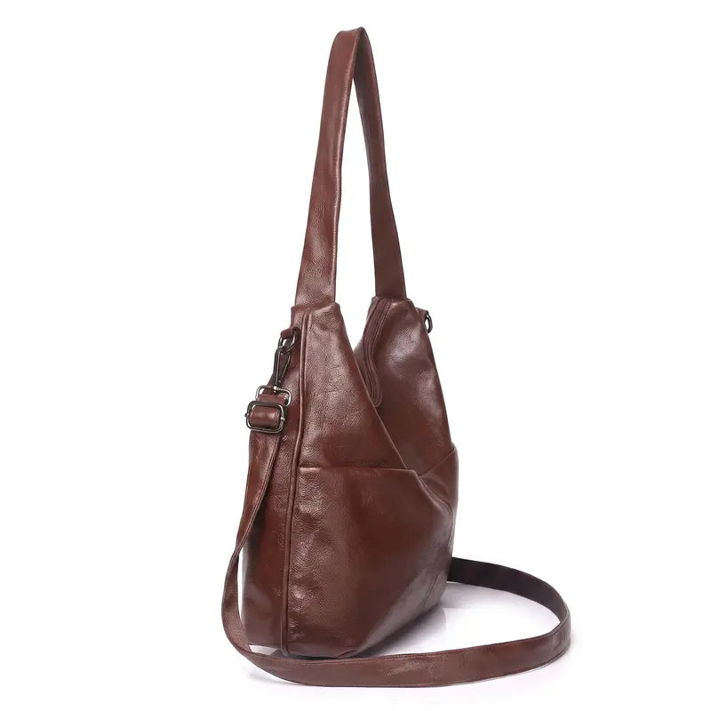 Bolsa hobo clássica castanho em couro legítimo em detalhe, destacando textura, alça e acabamento do couro.