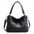 Bolsa hobo couro genuíno preta retrô em vista frontal, com formato, alça e ferragens visíveis, sobre fundo claro