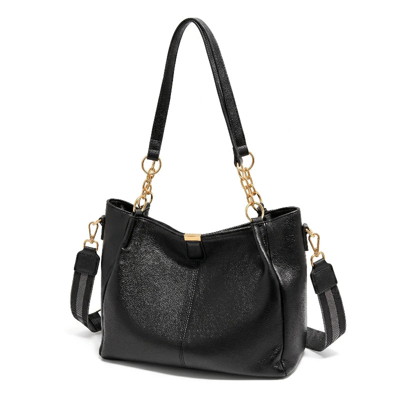 Bolsa hobo preta com corrente dourada em close no fecho e nas ferragens, com textura e brilho em destaque