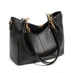 Bolsa hobo preta com corrente dourada em vista lateral, com profundidade, alça e acabamento visíveis, sobre fundo claro