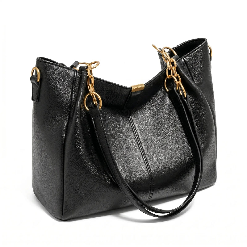 Bolsa hobo preta com corrente dourada em vista lateral, com profundidade, alça e acabamento visíveis, sobre fundo claro