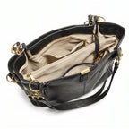 Bolsa hobo preta com corrente dourada aberta por cima, com forro, espaço interno e fechamento visíveis, sobre fundo claro