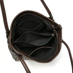 Bolsa hobo vintage marrom café aberta por cima, com forro, espaço interno e fechamento visíveis, sobre fundo claro