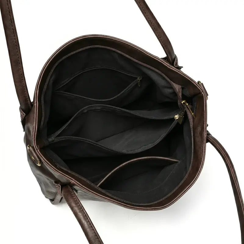 Bolsa hobo vintage marrom café aberta por cima, com forro, espaço interno e fechamento visíveis, sobre fundo claro