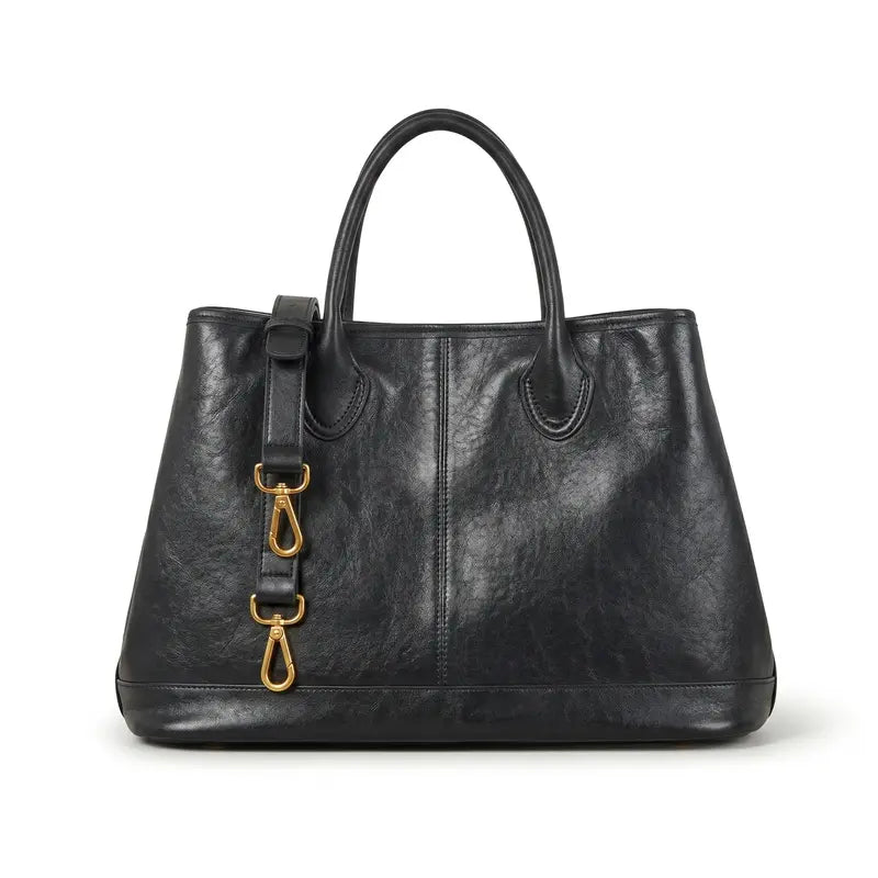 Bolsa shopper feminina preta em couro legítimo em ângulo três-quartos, mostrando formato amplo, costuras e alça longa
