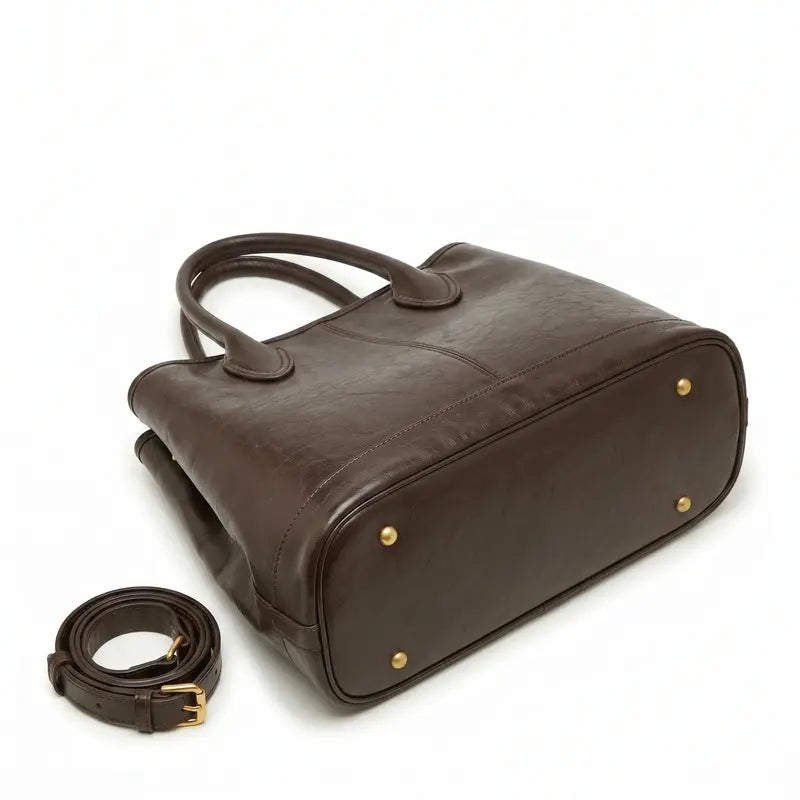 Bolsa tote de ombro em couro macio em composição de produto, mostrando formato, alça e volume da bolsa.