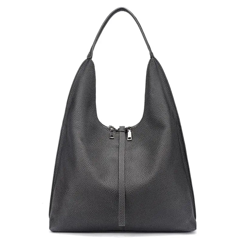 Bolsa tote feminina preta em couro legítimo usada pela modelo, mostrando proporção e caimento no ombro