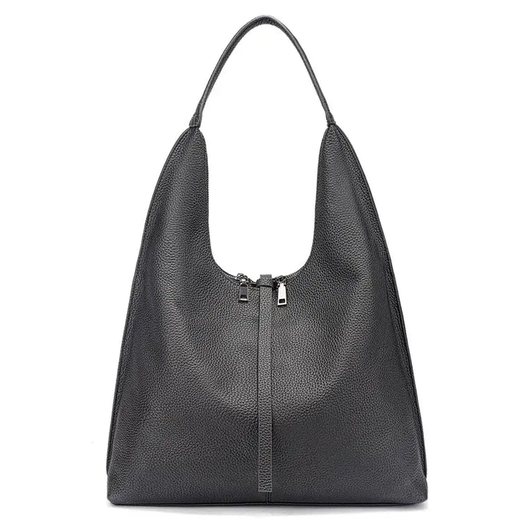 Bolsa tote feminina preta em couro legítimo usada pela modelo, mostrando proporção e caimento no ombro