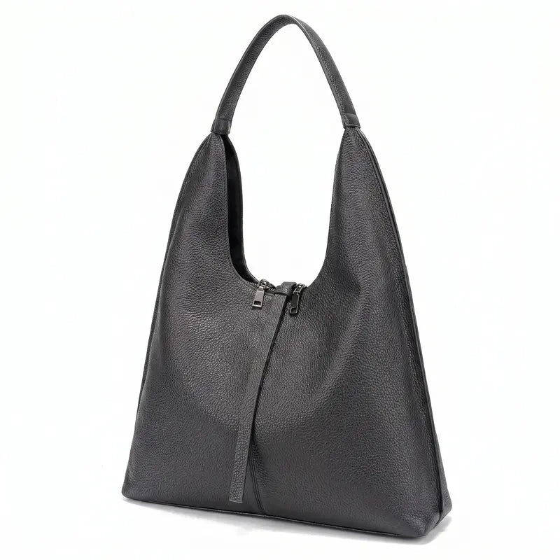 Bolsa tote feminina preta em couro legítimo em close na textura, costuras e acabamento do material